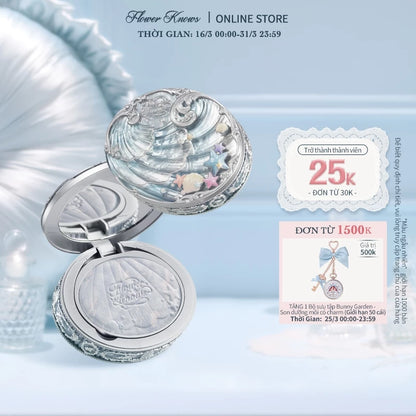 Silver seashell compact mirror displayed on a light blue background